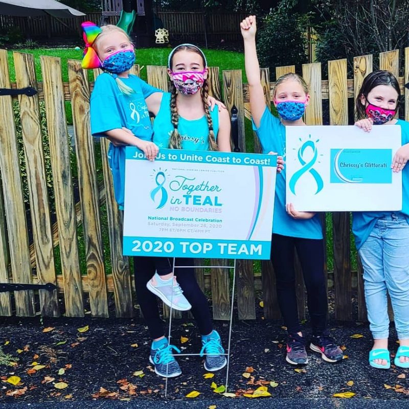 Masked children cheering by a Together in Teal poster as a top fundraising team