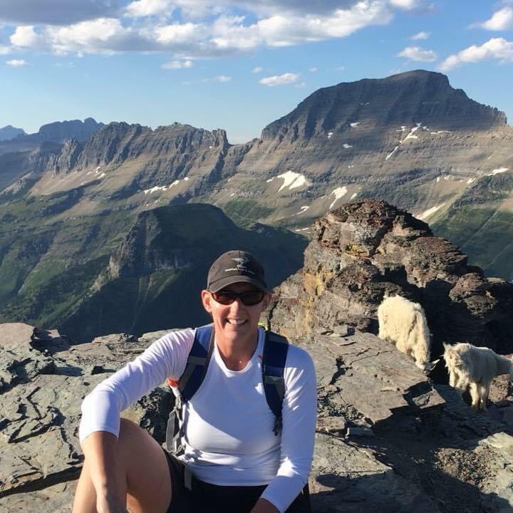 an ovarian cancer survivor sitting on a ledge overlooking mountain range