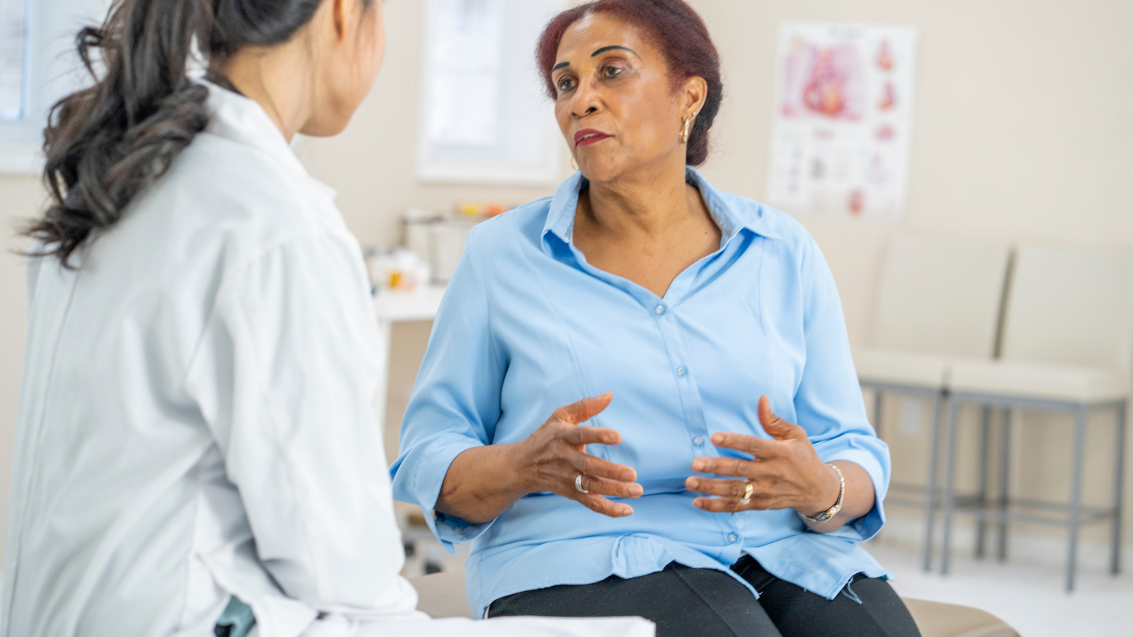 A middle-aged Black female talks to her female physician