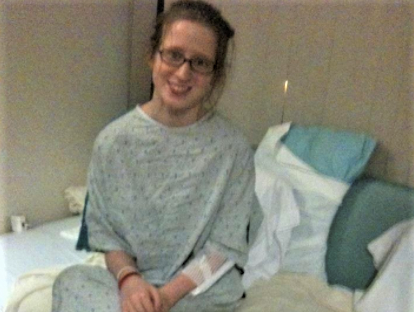 A young ovarian cancer patient sits at the edge of her hospital bed