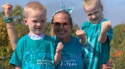 A mom and her two young kids wearing together in teal shirts to raise awareness of ovarian cancer